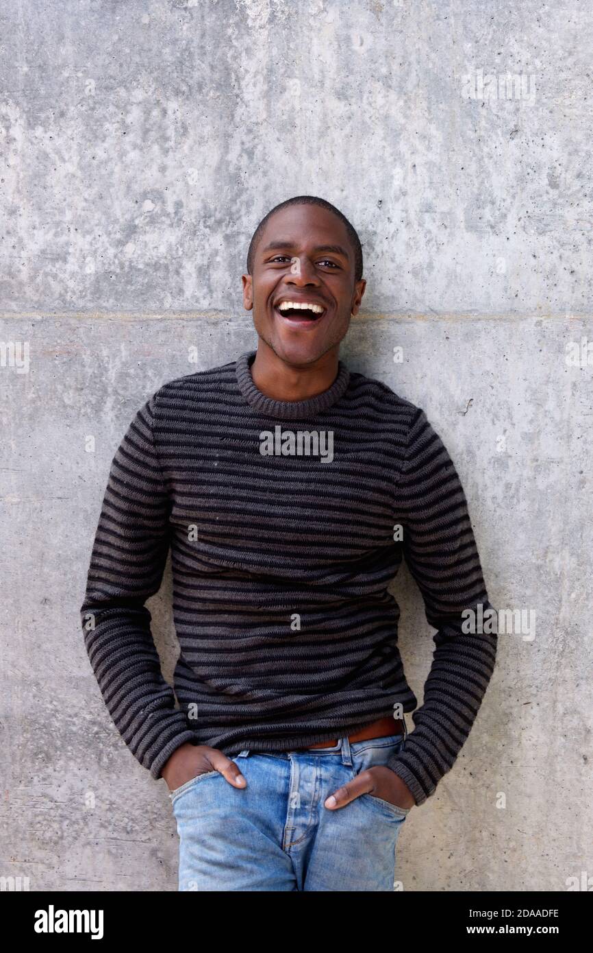 Portrait of cheerful african american man in sweater with hands in pockets Stock Photo