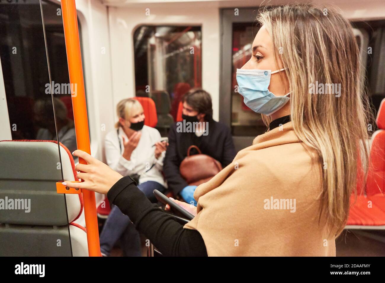 Woman as a passenger with face mask due to the Covid-19 pandemic in local public transport Stock Photo