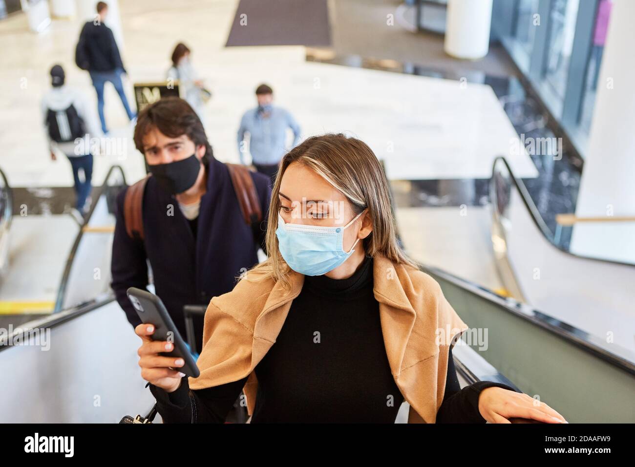 Business woman with face mask reads warning on smartphone about Covid ...