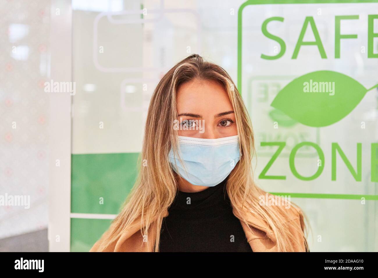 Young woman passerby with face mask because of Covid-19 pandemic while shopping Stock Photo