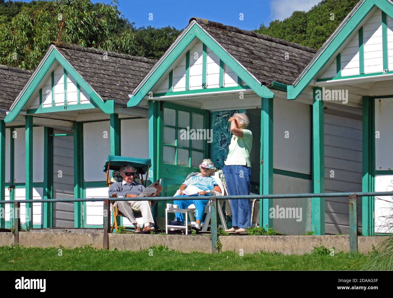People relaxing in the beach huts at Langland Bay near Swansea. Stock Photo
