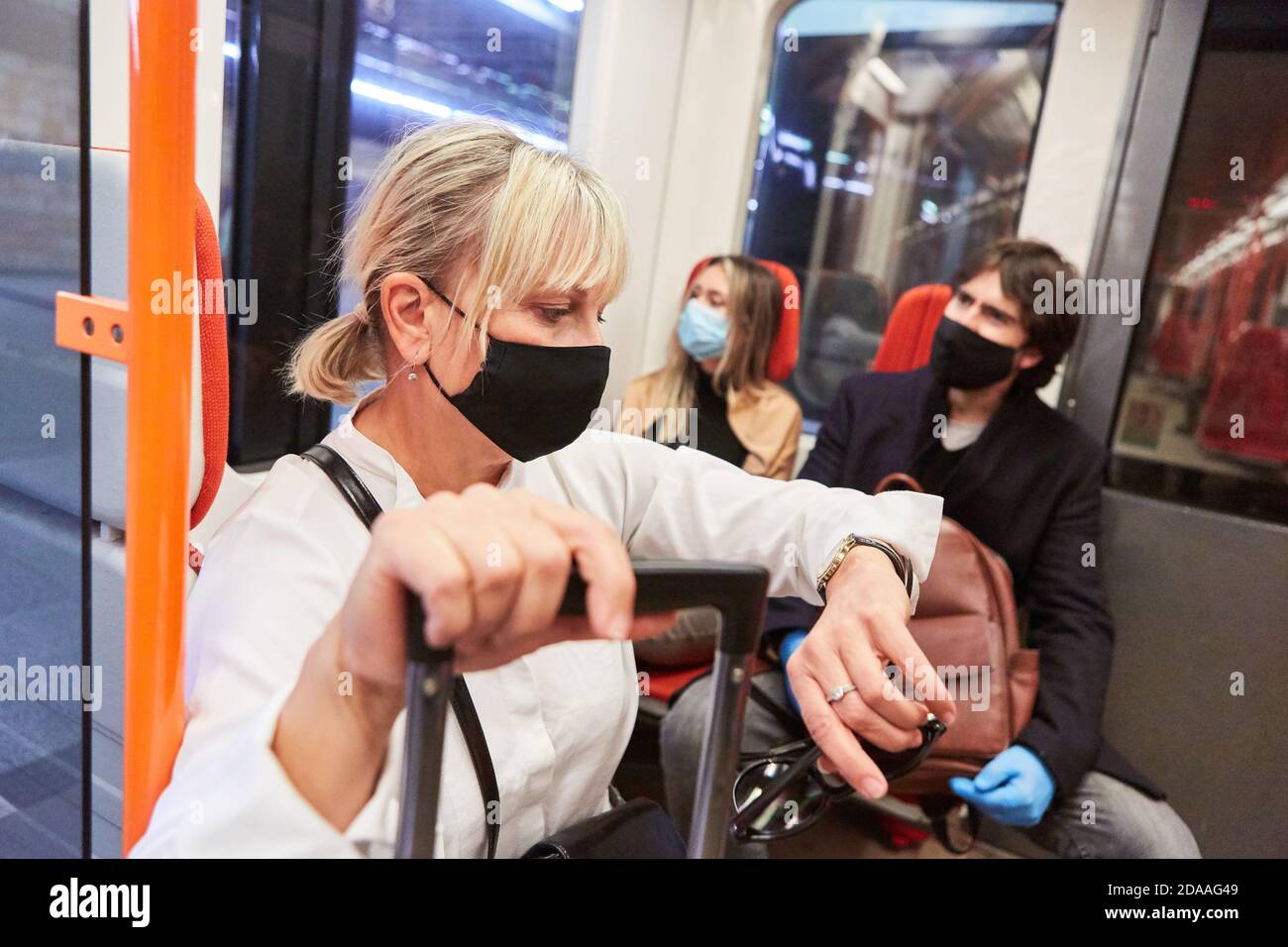 Mask requirement in local public transport due to Covid-19 pandemic with passengers on bus and train Stock Photo