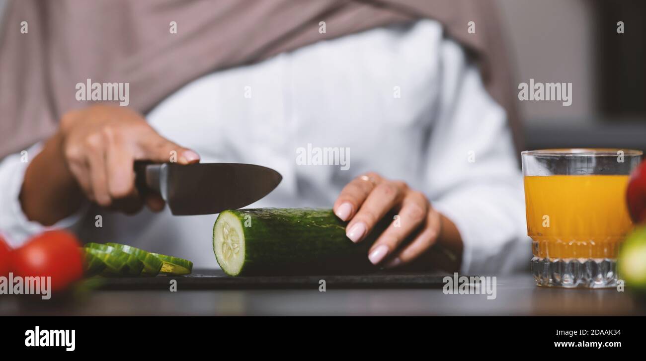 Muslim Woman's Hands Cutting Vegetables For Salad Cooking In Kitchen Stock Photo