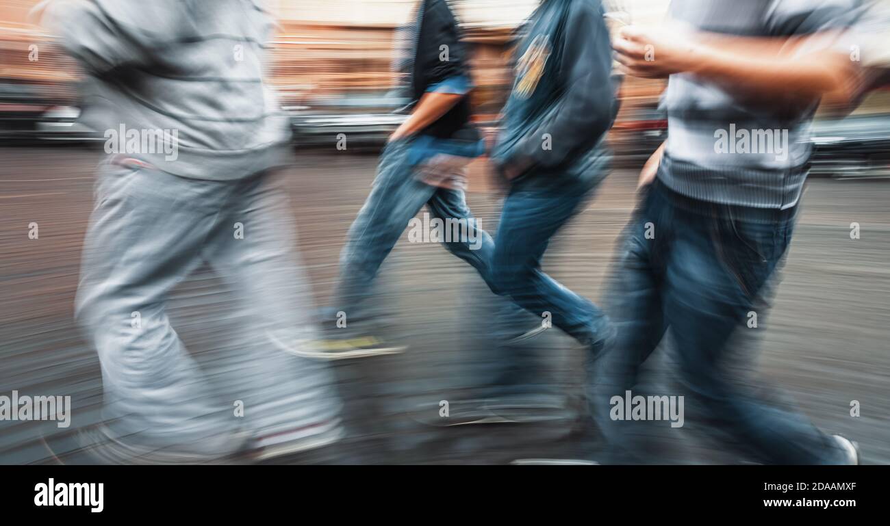 City life concept. People rushing in city. Abstract street scene in motion blur. A group of young guys walking down the street doing their business Stock Photo