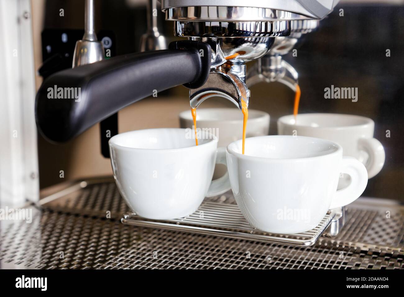 Coffee brewing in coffee machine. Espresso pouring in two white cups