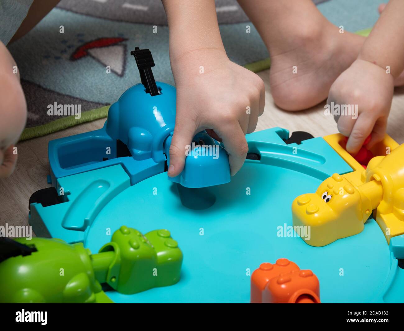 Children play a fun Board game where hippos eat balls. reaction games