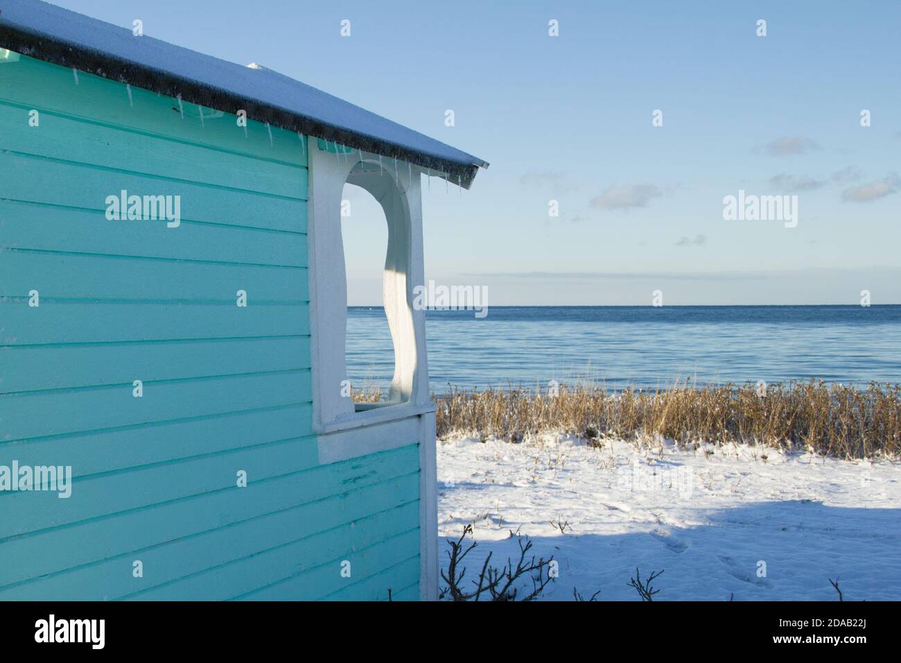 Candy coloured beach hut decorating the snowy beach of Skanor in south of Sweden Stock Photo