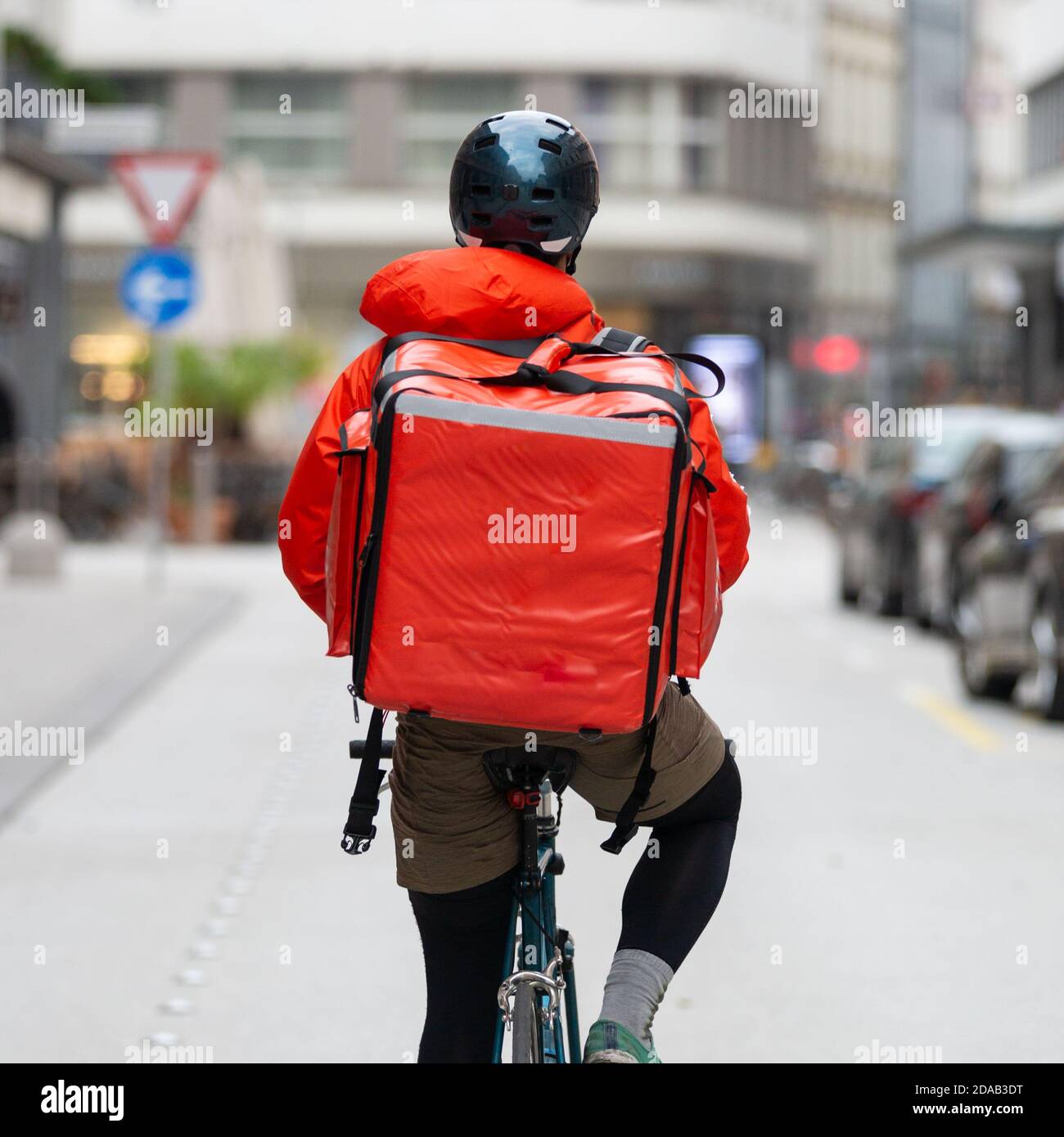 Courier On Bicycle Delivering Food In City. Stock Photo
