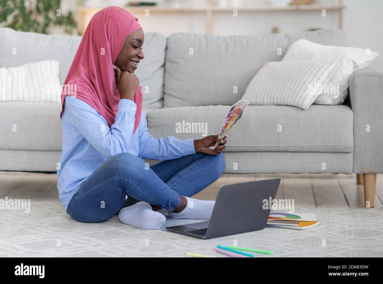 Black Muslim Female Graphic Designer Working Remotely At Home, Holding  Color Samples Stock Photo - Alamy
