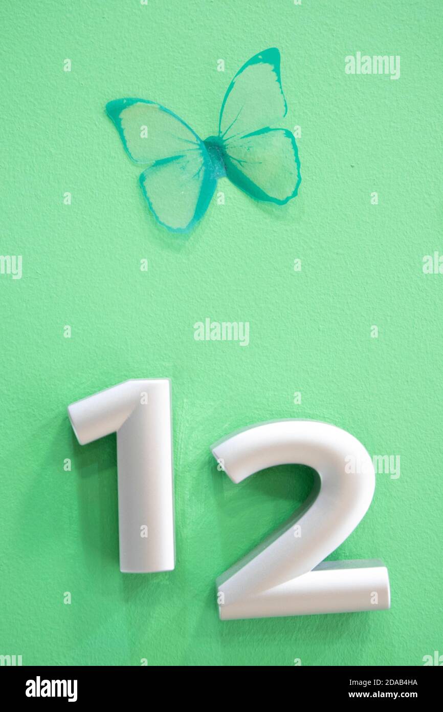 Numbers on green background with green butterfly Stock Photo