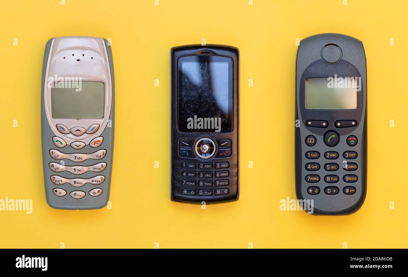Horizontal top view of three old and scratched mobile phones Stock Photo