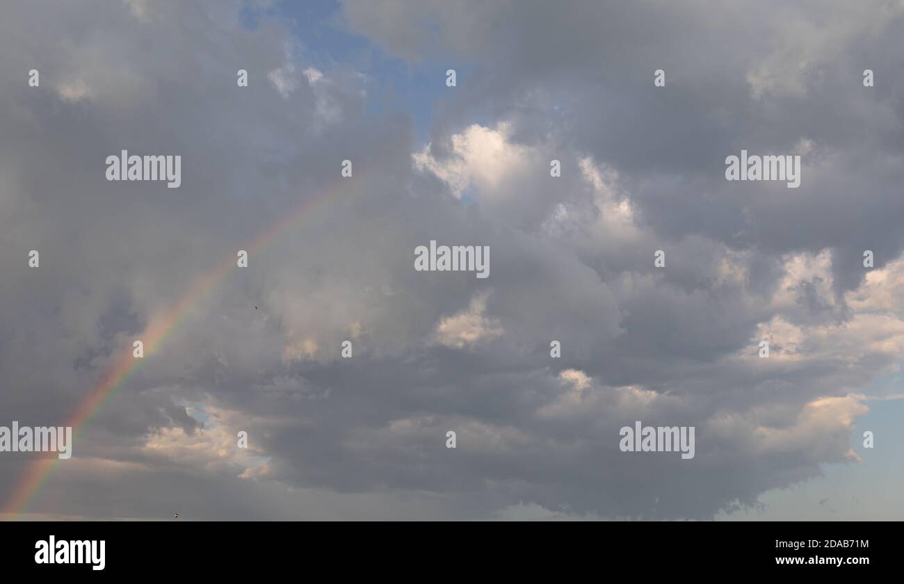 Rainbow in the sky against dramatic clouds Stock Photo - Alamy
