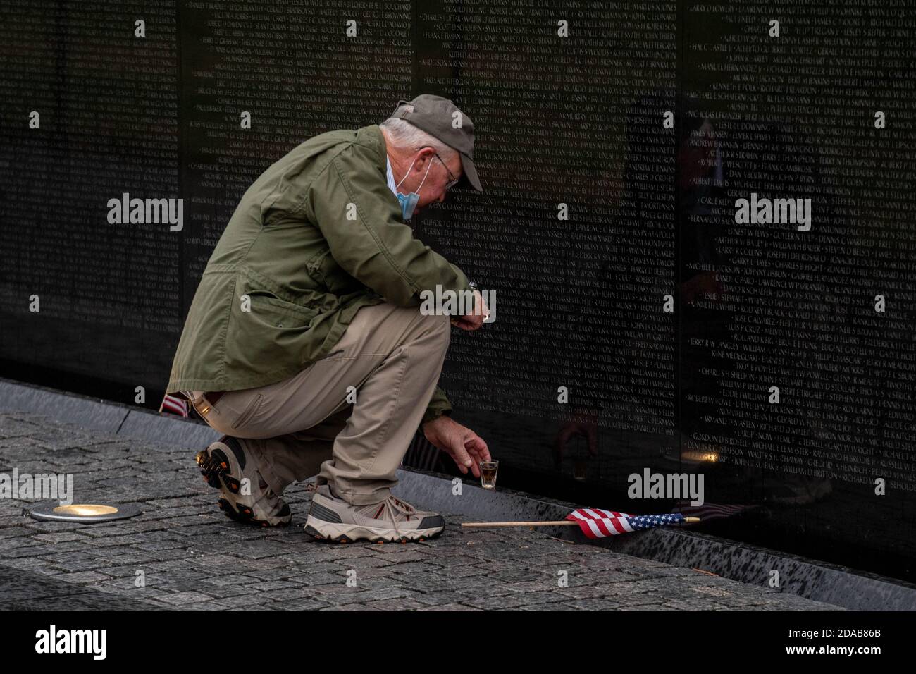 Washington, United States. 11th Nov, 2020. Jack Cowling, a Marine Corp veteran, HMM 364, visits the site of his good buddy Staff Sergeant Barney Barnhart at the Vietnam Memorial on Veterans Day in Washington, DC on Wednesday, November 11, 2020. Cowling does a shot of Jack Daniels and leaves another shot for his friend at the site every year. Veterans Day is a federal holiday in the United States observed annually on November 11, for honoring military veterans who have served in the United States Armed Forces. Photo by Ken Cedeno/UPI Credit: UPI/Alamy Live News Stock Photo