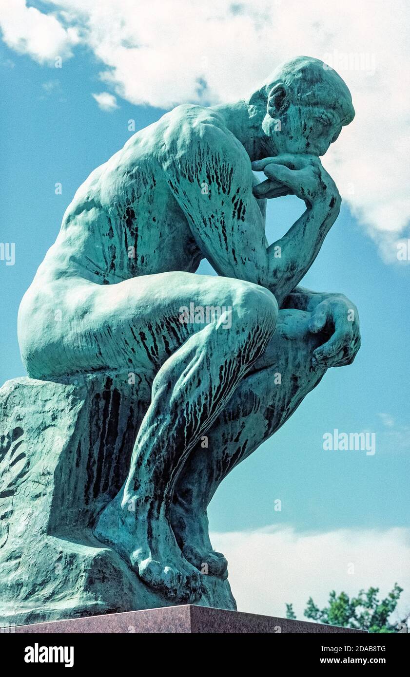 One of the 25 six-foot-tall bronze statues of "The Thinker" by famed French sculptor Auguste Rodin sits in front of the Nelson-Atkins Museum of Art in Kansas City, Missouri, USA. It was cast after the artist's death in 1917 and purchased for public display in that Midwestern American city in 1948. Air pollution, especially acid rain, can harm the greenish patina of copper-based bronze sculptures and sometimes cause black streaking to occur on the surface, as seen here. Stock Photo