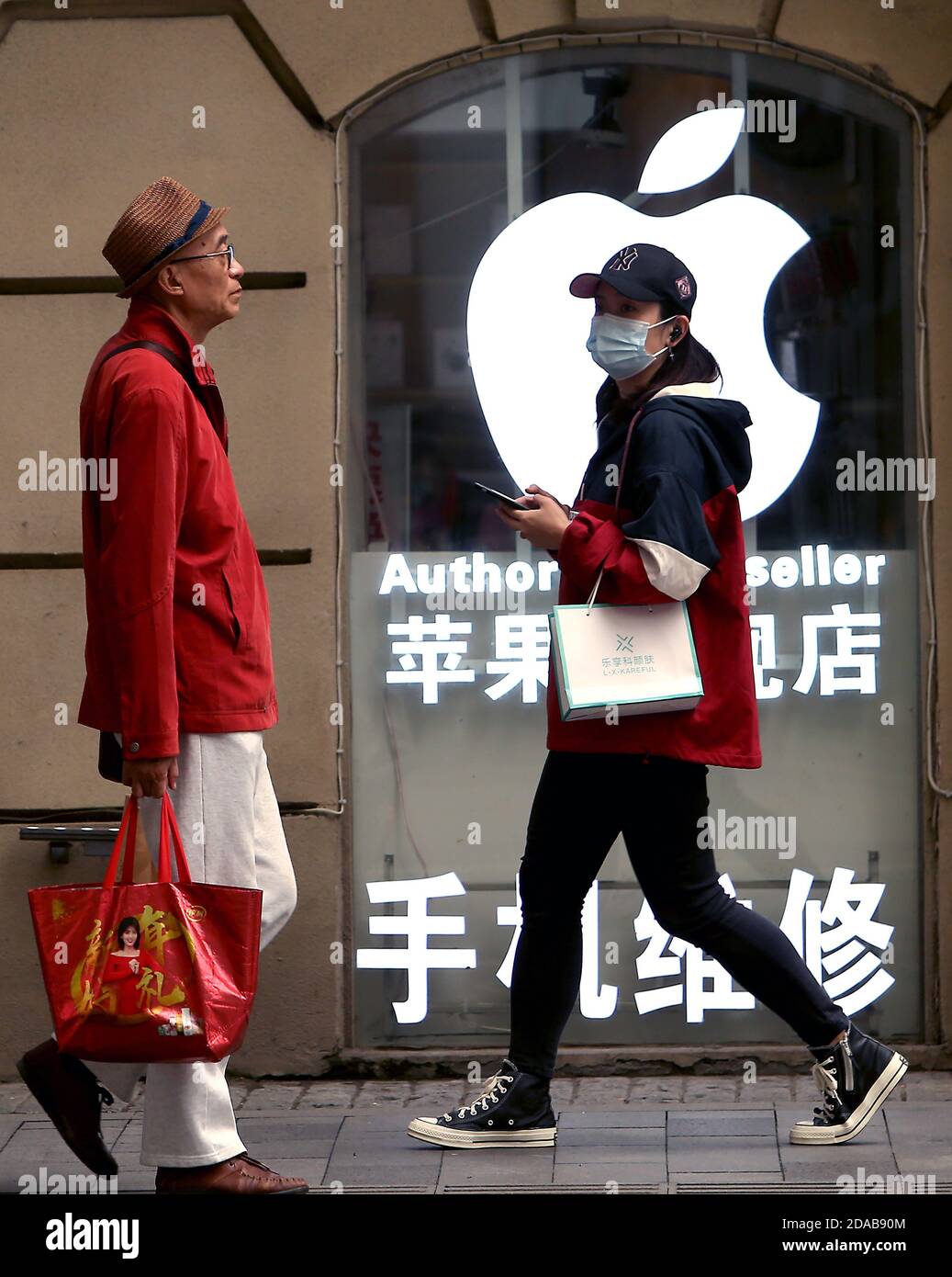 People walk past an Apple store in Beijing on Wednesday, November 11, 2020.  Apple has revealed it earned $7.9 billion in sales in China, down considerably from last year's $11.1 billion - about a 30% drop in the 4th quarter.  However, Apple's Tim Cook said it still exceeded Apple's expectations.       Photo by Stephen Shaver/UPI Stock Photo