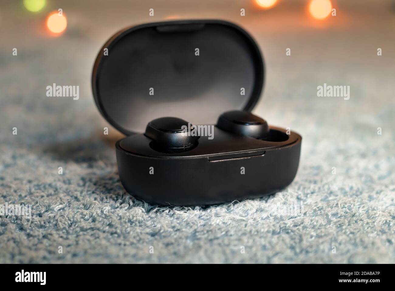 Wireless black headphones isolated on gray plush Stock Photo