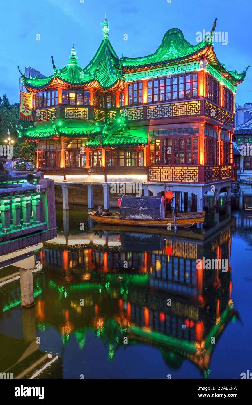 Beautifully illuminated famous Huxinting Teahouse in Yu Garden, Shanghai, China at night. The structure, sitting on a pond is conected via a zigzag br Stock Photo