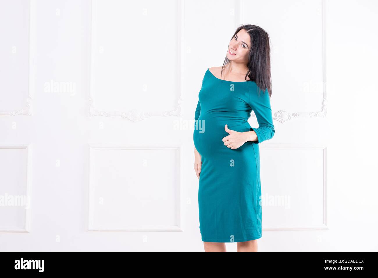 A pregnant girl in a dress with a big belly. Stock Photo