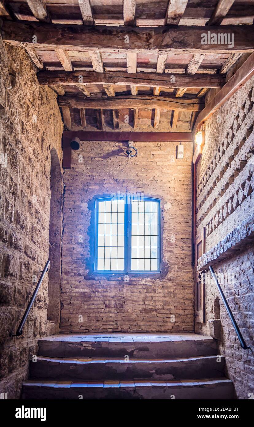 Staircase, window, corridor and ceiling with wooden beams in medieval tower in San Gimignano, Italy Stock Photo