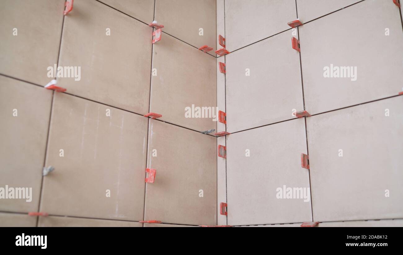 Repair of tiles in the bathroom. Close up of tiles fixing wall tiles