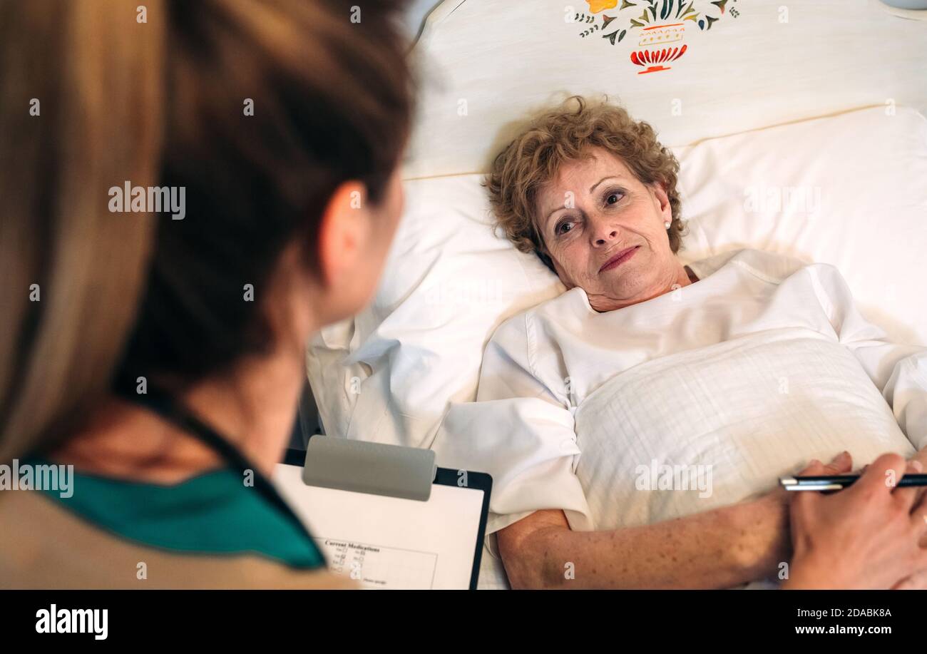 Female doctor comforting older patient Stock Photo