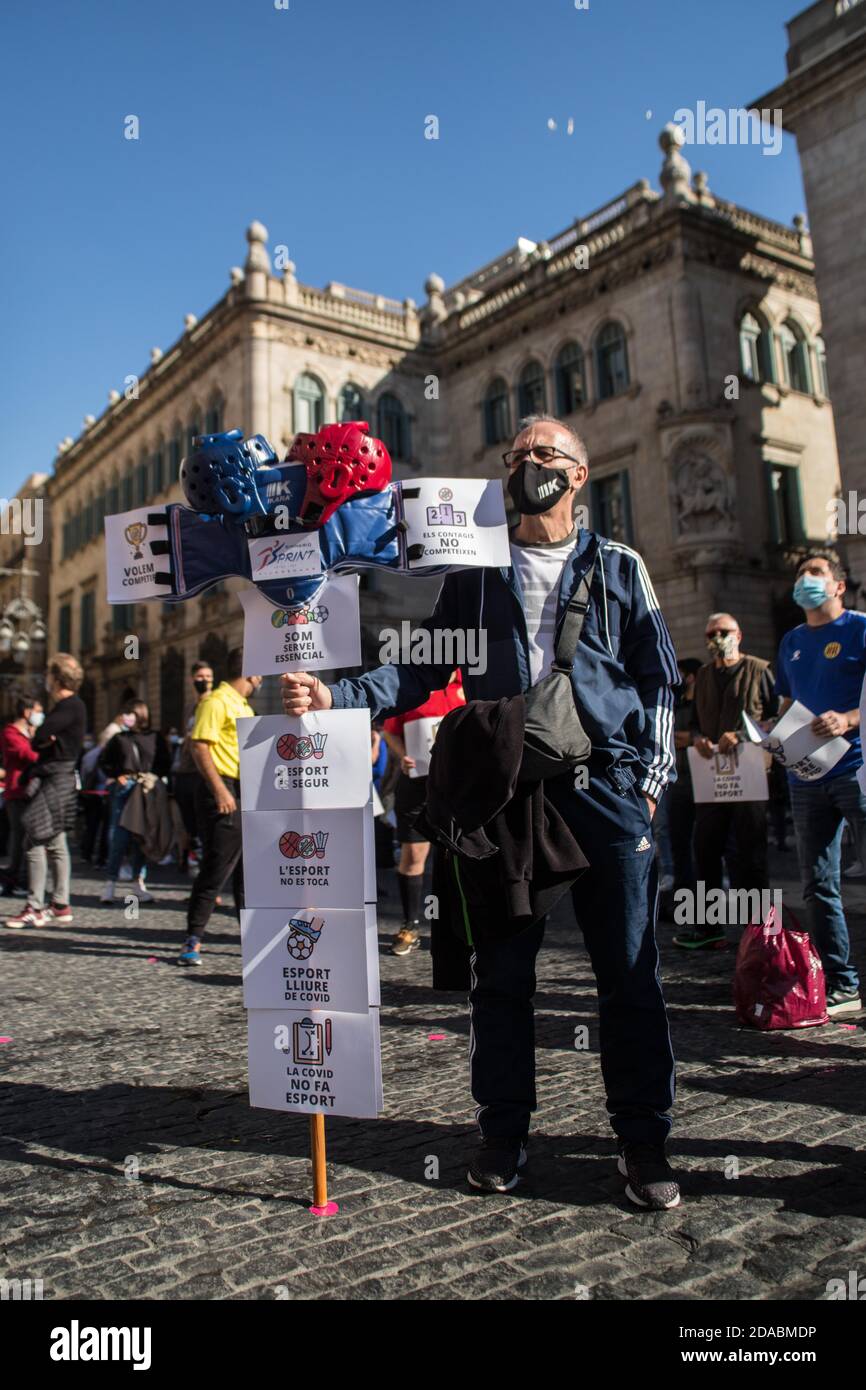 A protester wearing a face mask holds placards during the demonstration.Catalan sports federations and entities have demonstrated in Barcelona to demand the reopening of gyms and sports facilities in Catalonia. Stock Photo