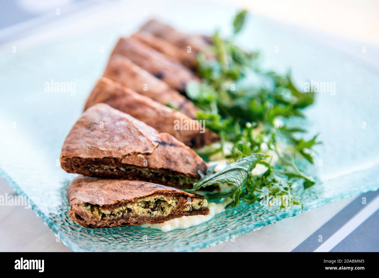 Cheese and herbs pie (pie made of carob flour) , a great appetizer in a restaurant (Searocco) in Ierapetra town, Lassithi, Crete, Greece. Stock Photo