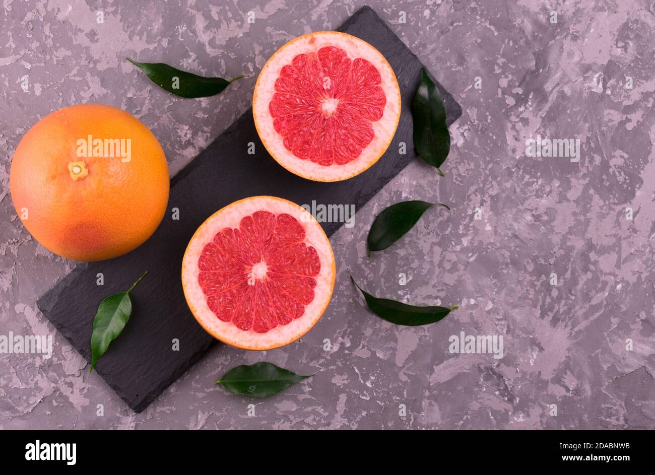 Grapefruits sliced ​​on a gray background. Flat lay. Stock Photo