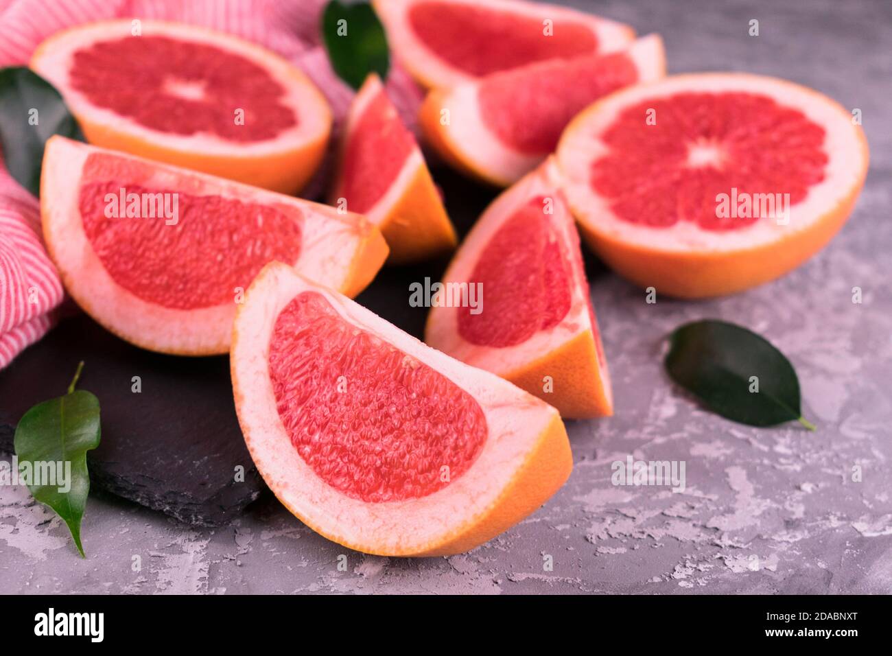 Sliced ​​grapefruit on a gray background. Stock Photo