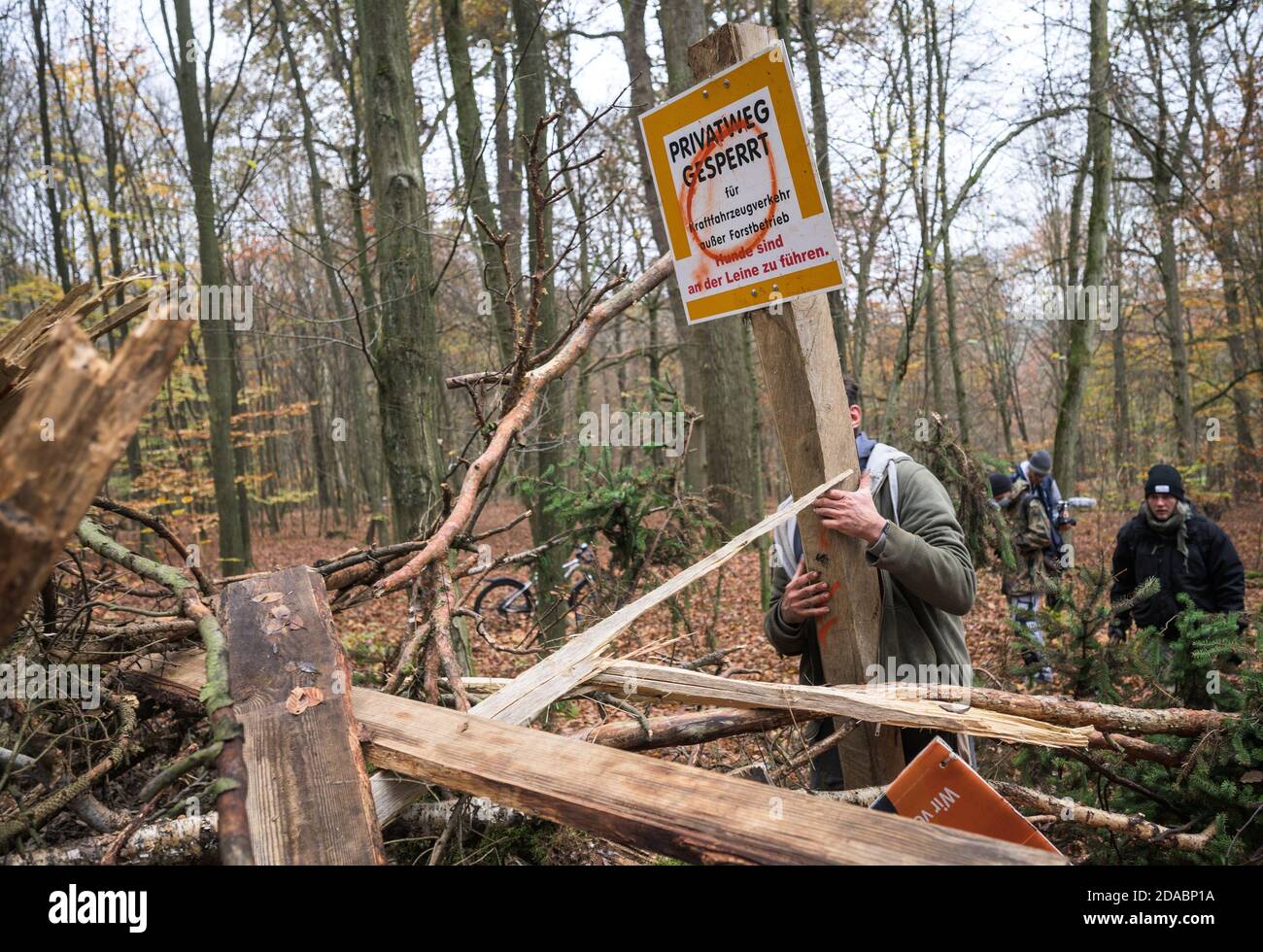 Kirtorf, Germany. 11th Nov, 2020. An activist puts up a sign 'Private road closed' in front of a barricade. Activists are currently occupying the Dannenröder Forst, demonstrating against the planned expansion of the Autobahn 49 (A49) and for the preservation of the forest area that would fall victim to the planned expansion. The police expect massive resistance to the imminent clearing of the Dannenröder Forst. Credit: Andreas Arnold/dpa/Alamy Live News Stock Photo