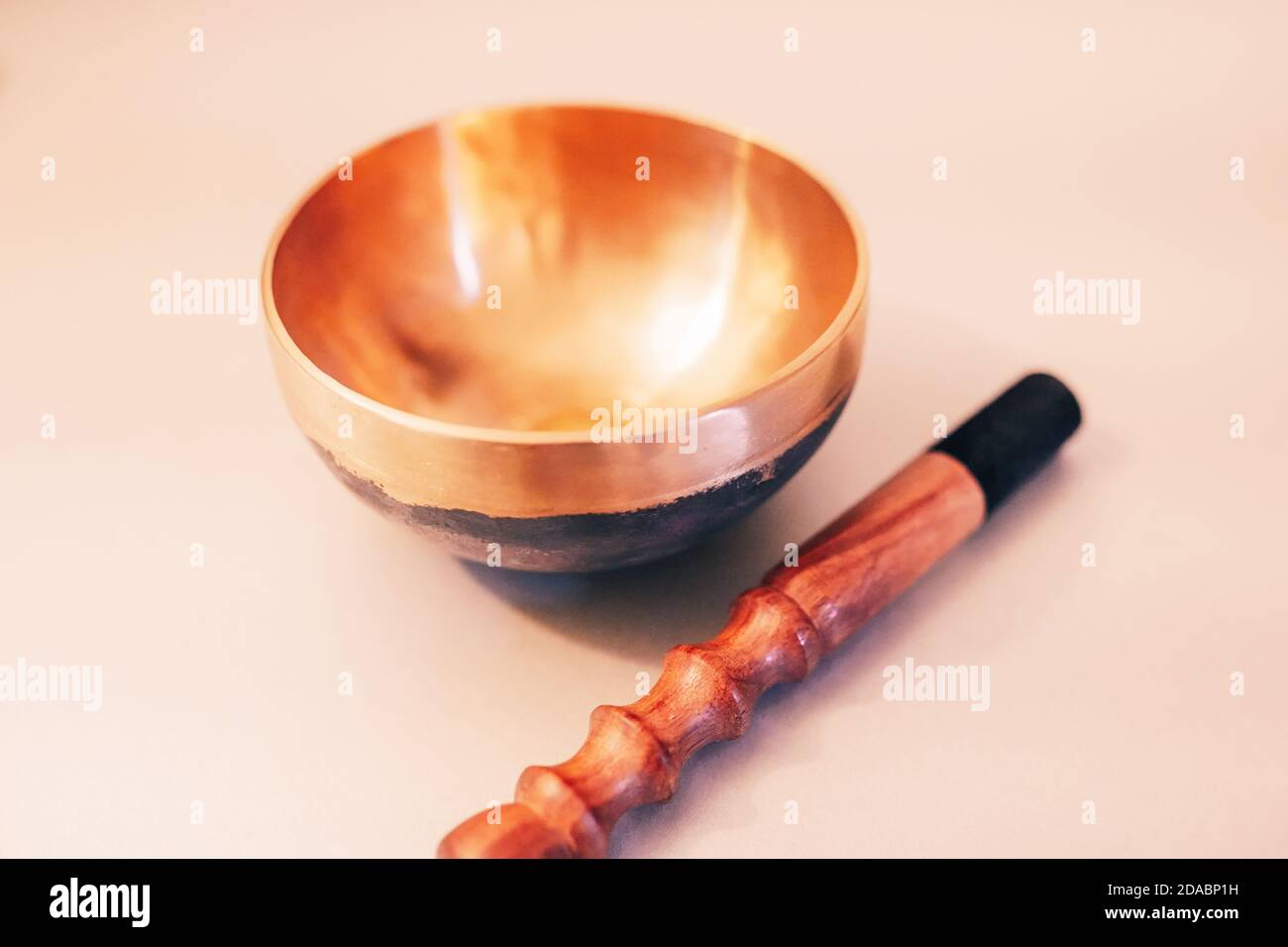Bronze tibetan singing bowl with wooden stick on the white background Stock Photo