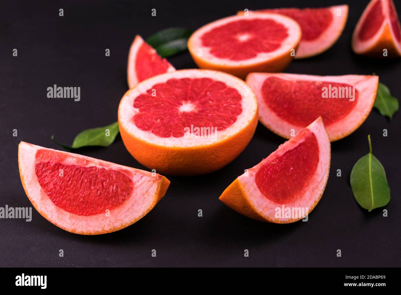 Sliced ​​grapefruit on a black background. Flat lay. Stock Photo