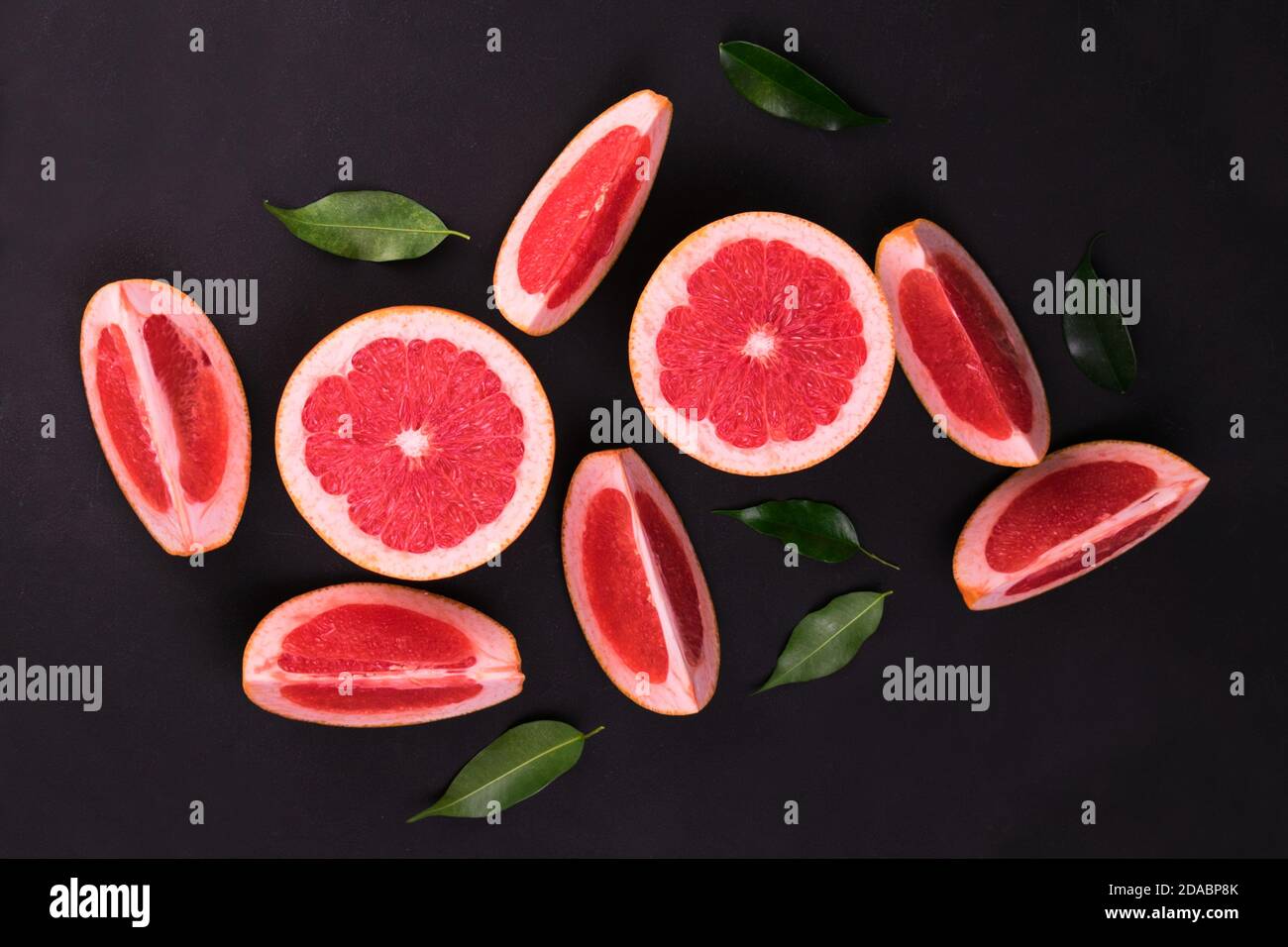Sliced ​​grapefruit on a black background. Flat lay. Stock Photo