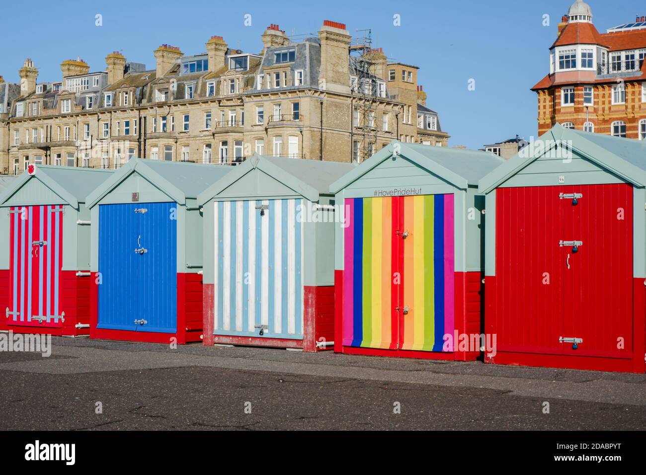 Colourful beach huts and pride beach hut along the promenade of Hove seafront, Brighton & Hove, East Sussex, UK Stock Photo