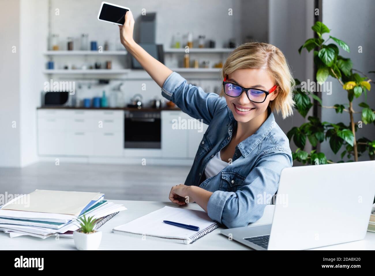 young blonde woman taking selfie while working from home Stock Photo ...