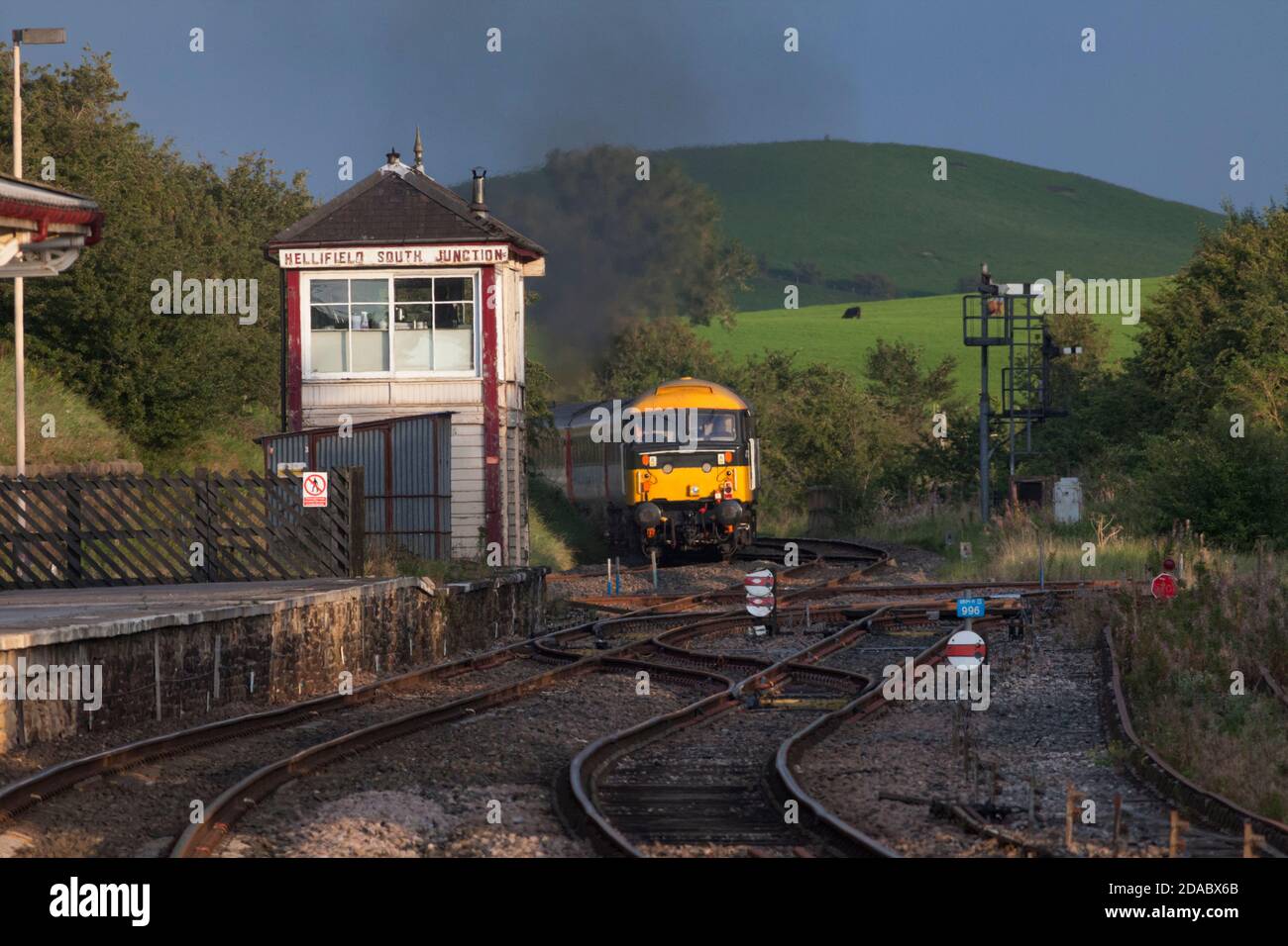 Preserved class 47 locomotive 47712 passing the midland railway signal box at Hellifield with a staycation express charter train Stock Photo