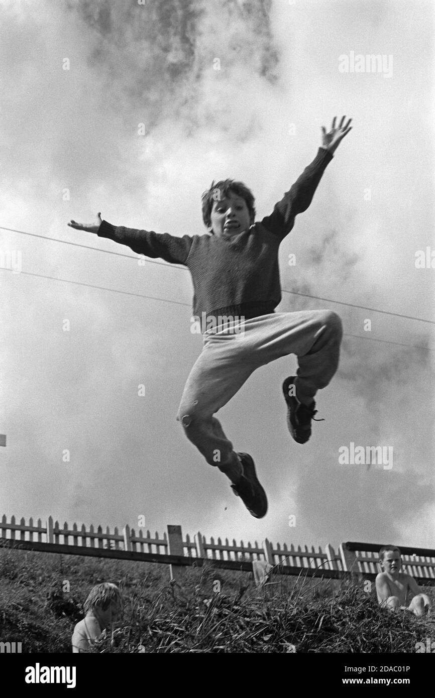 young boy jumping off a dune, August 1986, Ireland Stock Photo Alamy