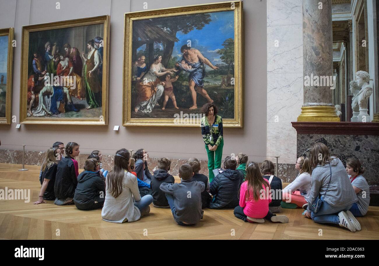 Docent at the Louvre art museum giving a tour to school children in