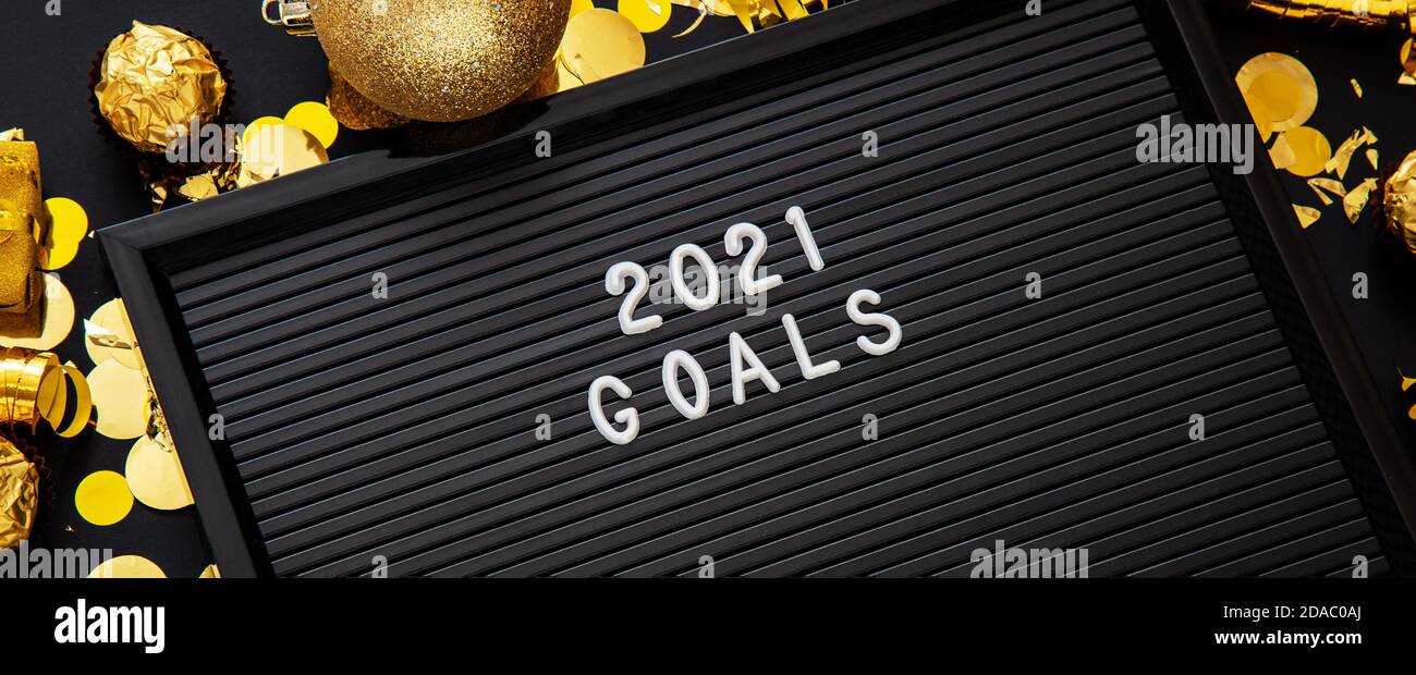 2021 Goals text on black Letter Board in Christmas festive decor, confetti balls. New year 2021 goals, resolution, check list with motivation or Stock Photo