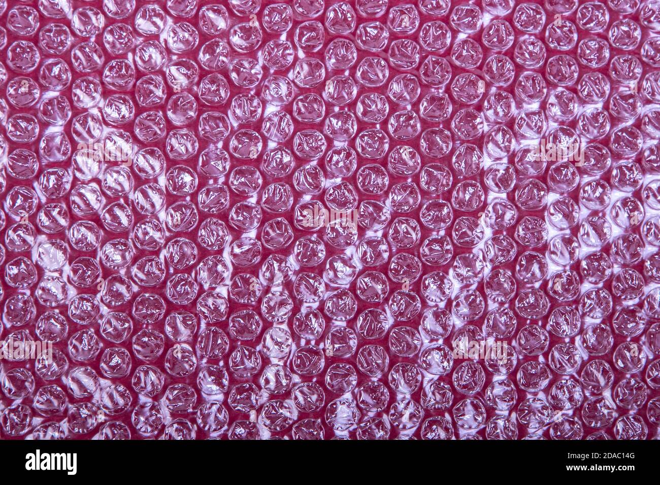 plastic bubble wrap on a red background, view from above Stock Photo