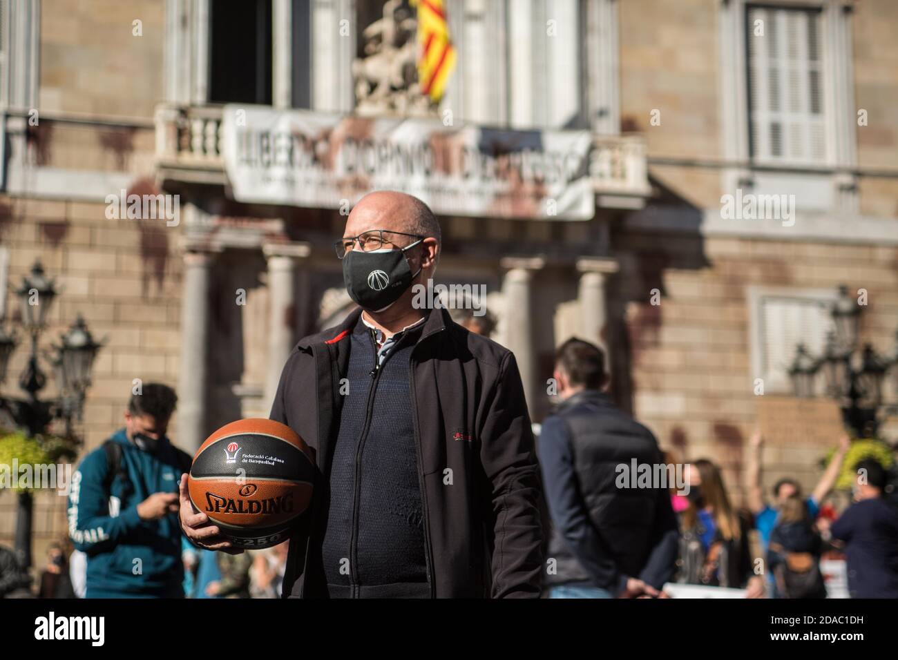 November 11, 2020: Protester with protection mask is seen with basketball.Catalan sports federations and entities have demonstrated in Barcelona to demand the reopening of gyms and sports facilities in Catalonia Credit: Thiago PrudÃªNcio/DAX/ZUMA Wire/Alamy Live News Stock Photo