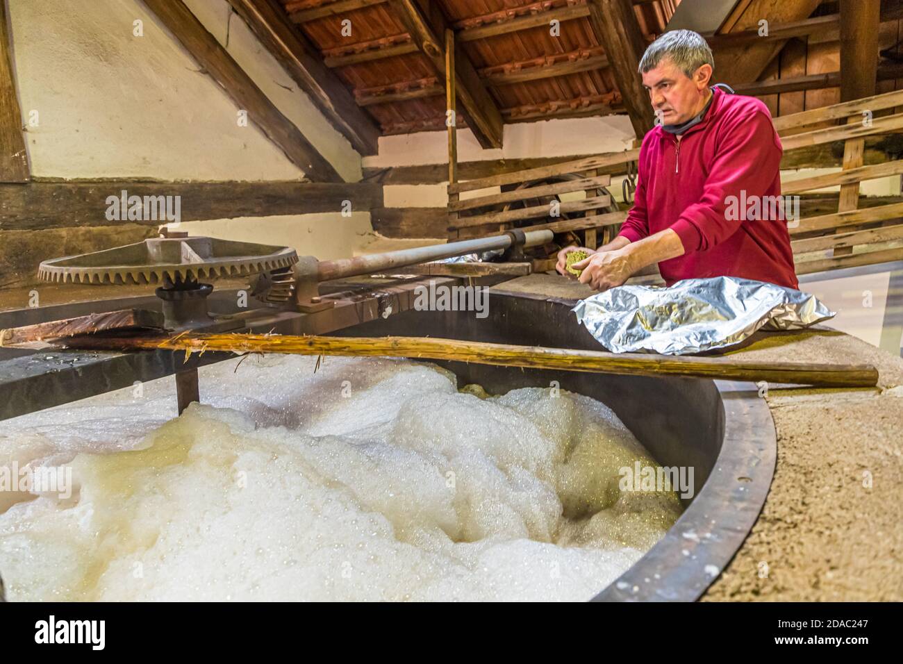Traditional Zoigl Brewery in Falkenberg, Germany. Shortly before boiling, brewmaster Sepp Neuber from the community of Falkenberg adds hops to the original wort of the future Zoigl beer. Boiling makes beer a 'safe' drink Stock Photo