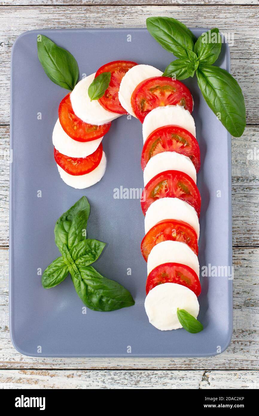 Christmas caprese salad in form of candy cane. Mozzarella and tomato on
