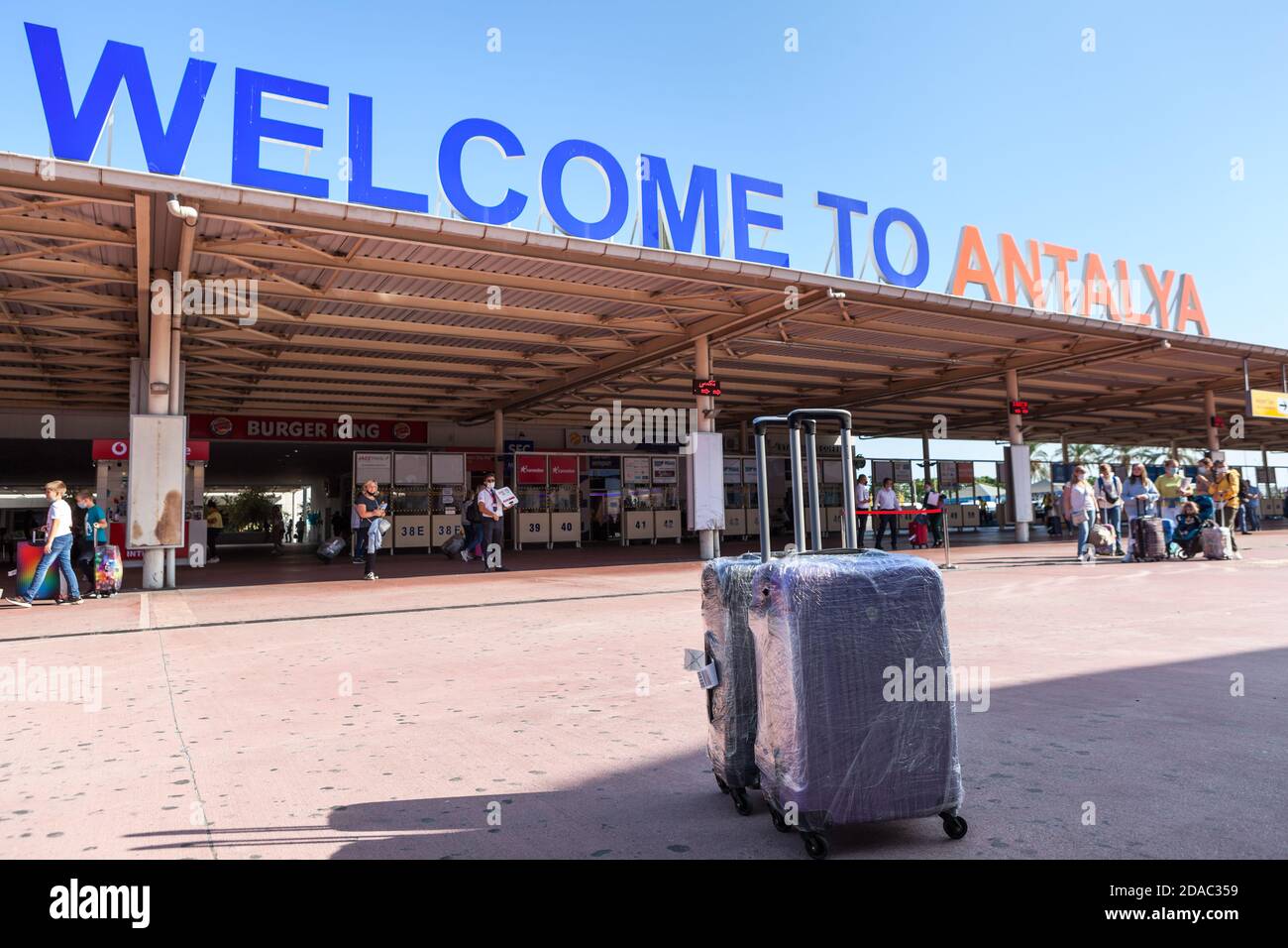 Antalya, Turkey-circa Oct, 2020: Two luggages stand against signboard of the Antalya International airport. Inscription the Welcome to Antalya is in a Stock Photo