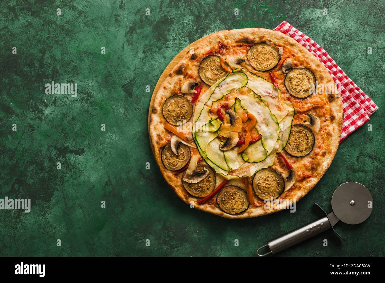Vegetarian vegetable pizza on a green background. Copspace Stock Photo