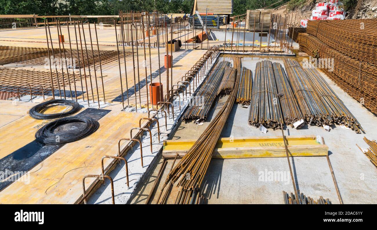 Bundles of steel rebar rods and grids into reinforced cement concrete at building site. Ferroconcrete reinforcing bars. Ceiling and floor slab or wall. Stock Photo