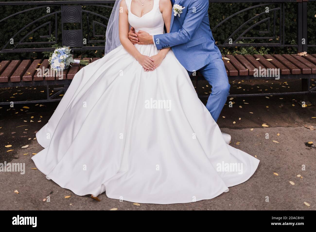 the groom and the bride sit on bench in the park Stock Photo - Alamy