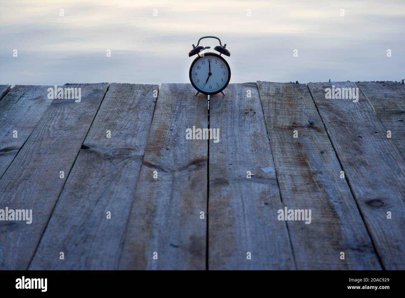 Clock On Bridge Summer time concept. Alarm clock on wooden bridge on sea sunrise ...