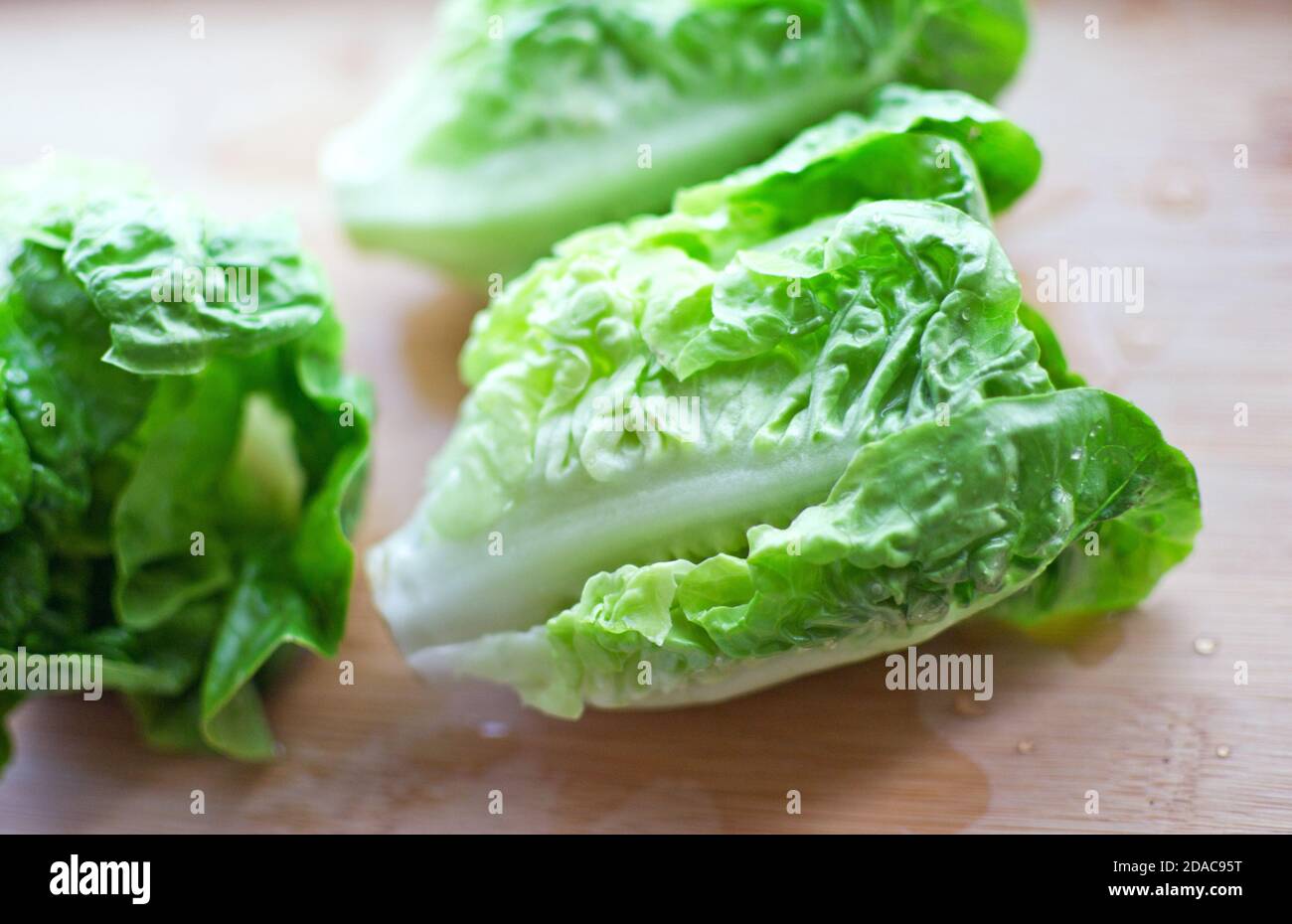 Fresh washed bundle of Romaine lettuce on the wooden cutting board