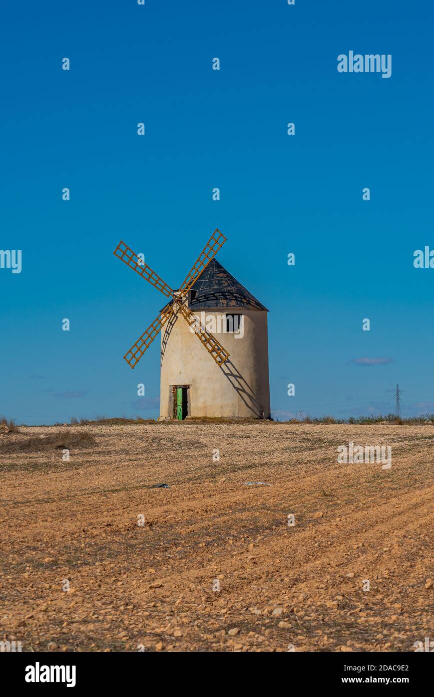 Windmill at the Don Quixote route in Spain on a sandy field, vertical